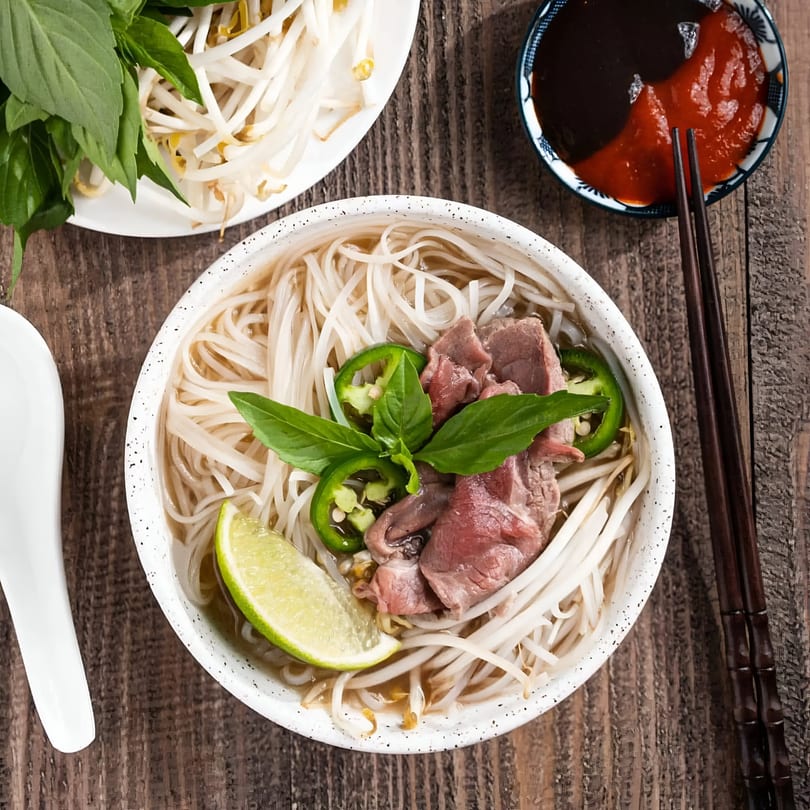 Pho Hoai's pho with beef, noodles, lime, jalapeños, and basil, with bean sprouts and sauces.